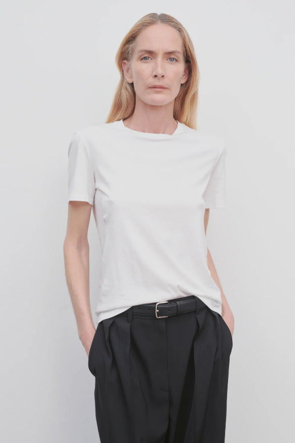Front view of white welser t-shirt on model wearing black trousers, against a white background.