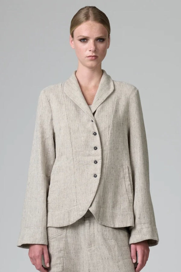 Front view of chalk herringbone jacket on model wearing chalk pants, against a grey background.