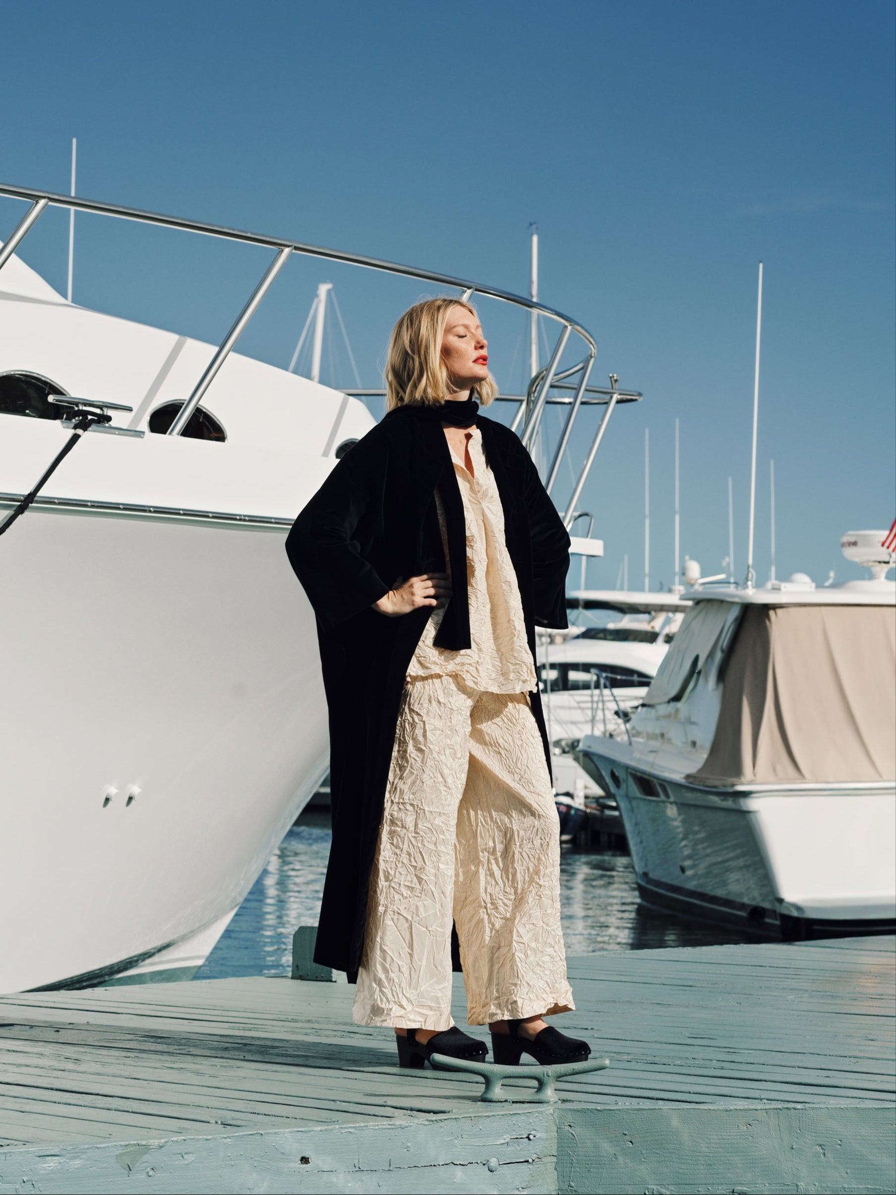 Woman standing on a dock with boats in the background