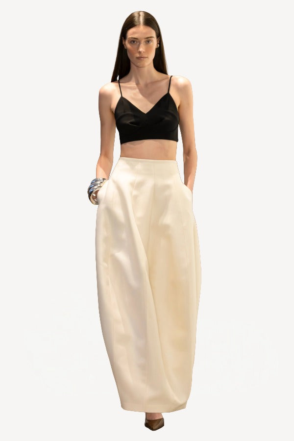 Front view of ivory callum persimmon skirt on model wearing black bralette, against a white background.
