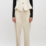 Front view of ivory william vest on model wearing ivory trousers, a black shirt and brown loafers, against a white background.