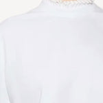 Front closeup view of blanc cropped t-shirt on model, against a white background.