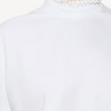 Front closeup view of blanc cropped t-shirt on model, against a white background.