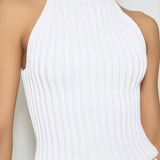 Front view of blanc halter top on model wearing white skirt, against a white background.