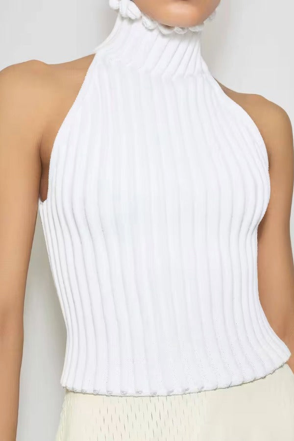 Front view of blanc halter top on model wearing white skirt, against a white background.