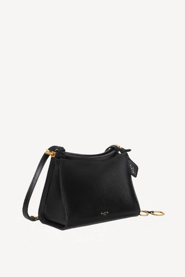 Side slanted view of noir le clicl small square bag on white background, with no model shown.