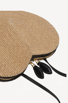 Side closeup view of the natural heart bag in straw on white background, with no model shown.