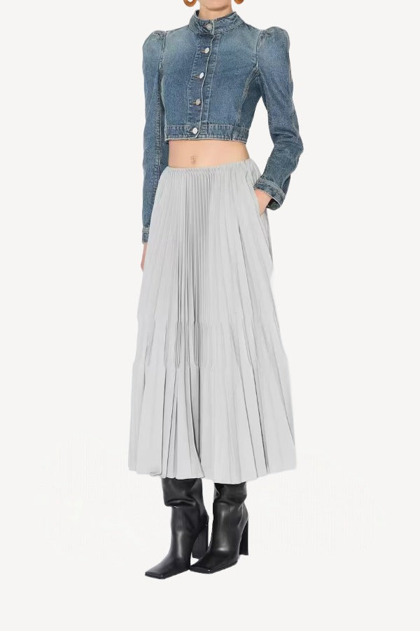Front view of gris souris pleated skirt on model wearing jean jacket and boots, against a white background.