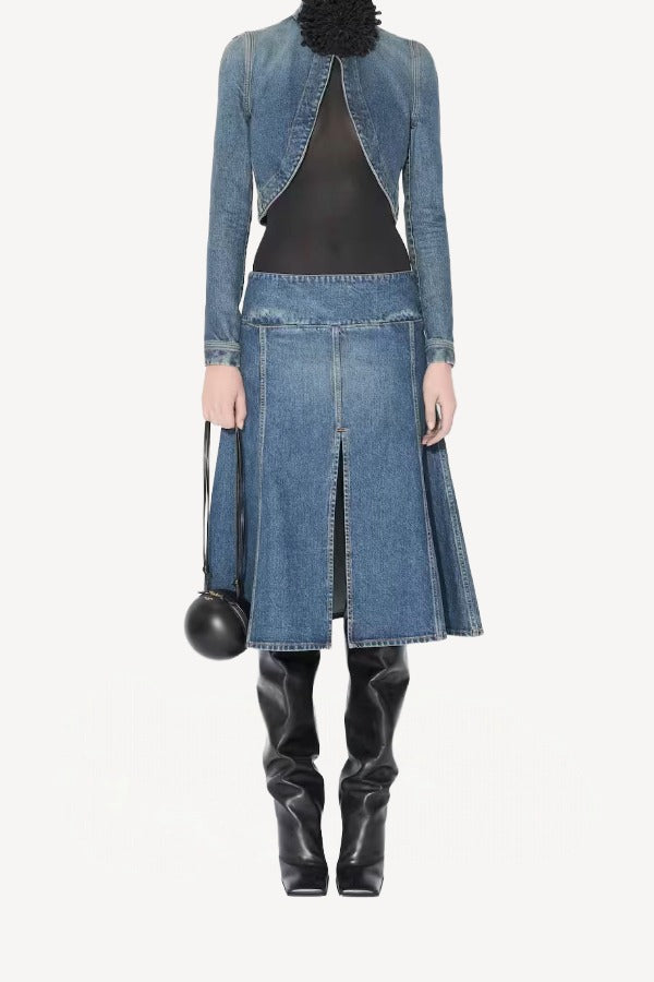 Front view of denim slit skirt on model wearing denim jacket, black bodysuit and boots, against a white background.