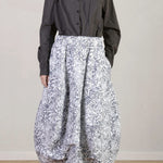 Front view of Bright Flower Carla Skirt on model wearing a dark grey top with black oxfords, against a white background.