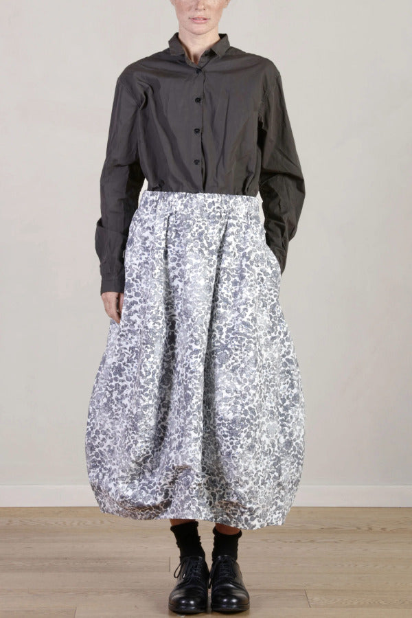 Front view of Bright Flower Carla Skirt on model wearing a dark grey top with black oxfords, against a white background.