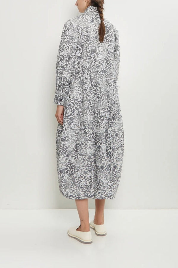 Back view of bright flower letty dress on model wearing white loafers, against a white background.