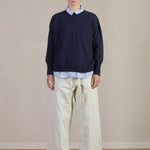 Front view of Stone Chloe Pants on model wearing stripe shirt and navy sweater with black oxfords, against a white background.