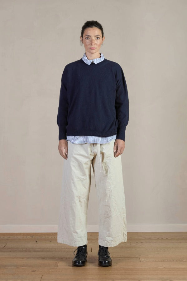 Front view of Stone Chloe Pants on model wearing stripe shirt and navy sweater with black oxfords, against a white background.