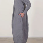 Side view of fog letty dress on model wearing black oxfords, against a white background.