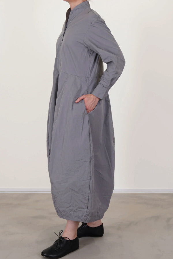 Side view of fog letty dress on model wearing black oxfords, against a white background.