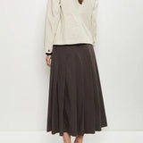Back view of stone caryl jacket on model wearing brown skirt and black loafers, against a white background.