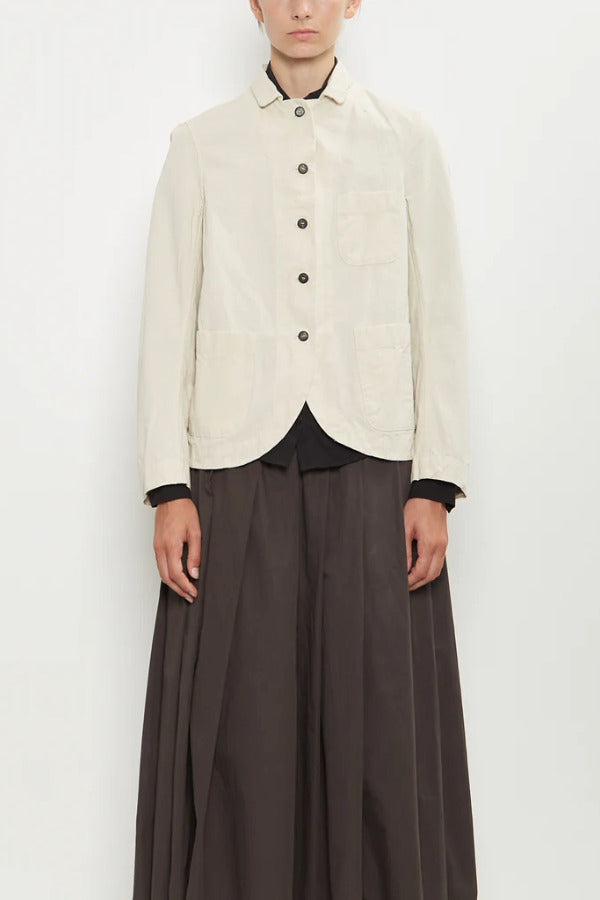 Front view of stone caryl jacket on model wearing brown skirt against a white background.