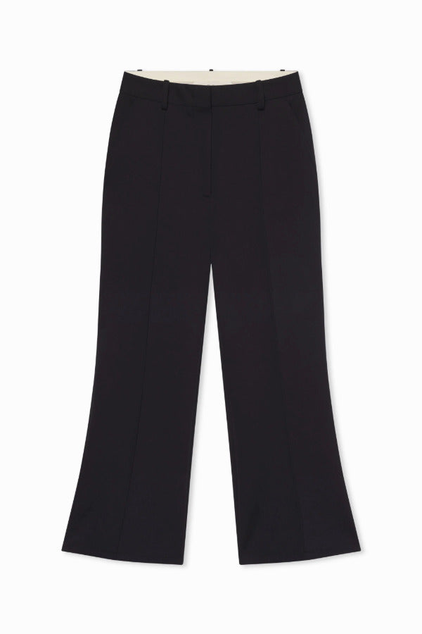 Front view of cropped flared pants on flat surface, with no model shown, against a white background.