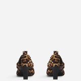 Back view of leopard calf hair pointed ruched pumps on white background, with no model shown.