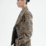 Side view of leopard peacoat on model wearing black top and pants, against a white background.