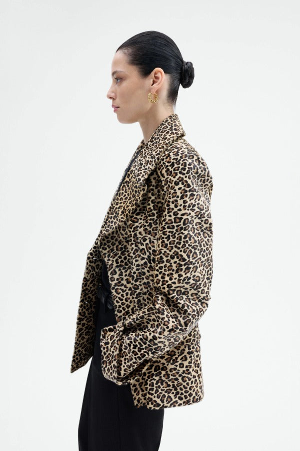 Side view of leopard peacoat on model wearing black top and pants, against a white background.