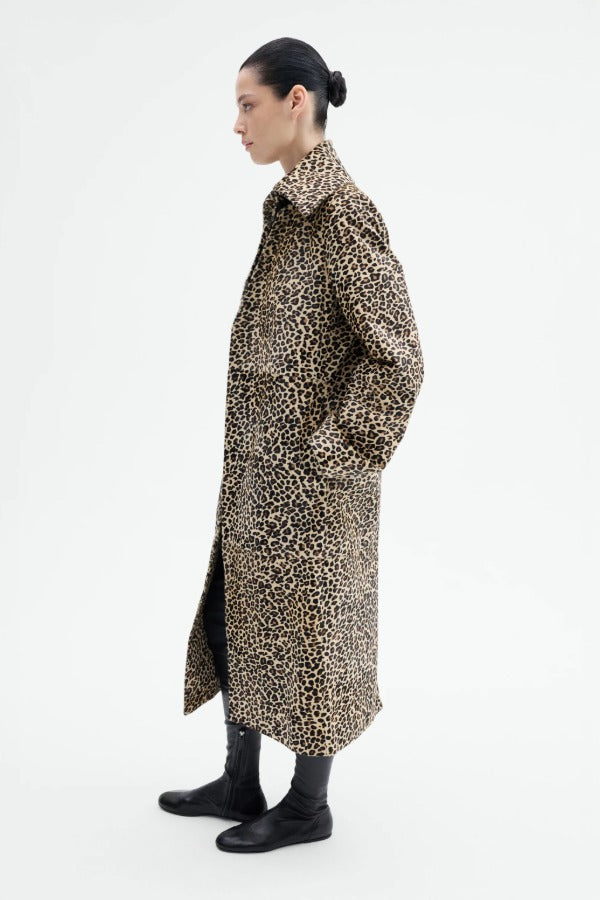 Side view of leopard coat on model wearing black top and flats, against a white background.