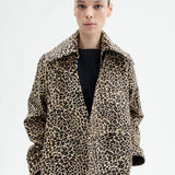 Front view closeup of leopard coat on model wearing black top, against a white background. 