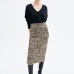 Front view of leopard skirt on model wearing black top and boots, against a white background.