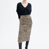 Front view of leopard skirt on model wearing black top and boots, against a white background.