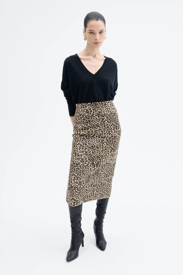 Front view of leopard skirt on model wearing black top and boots, against a white background.