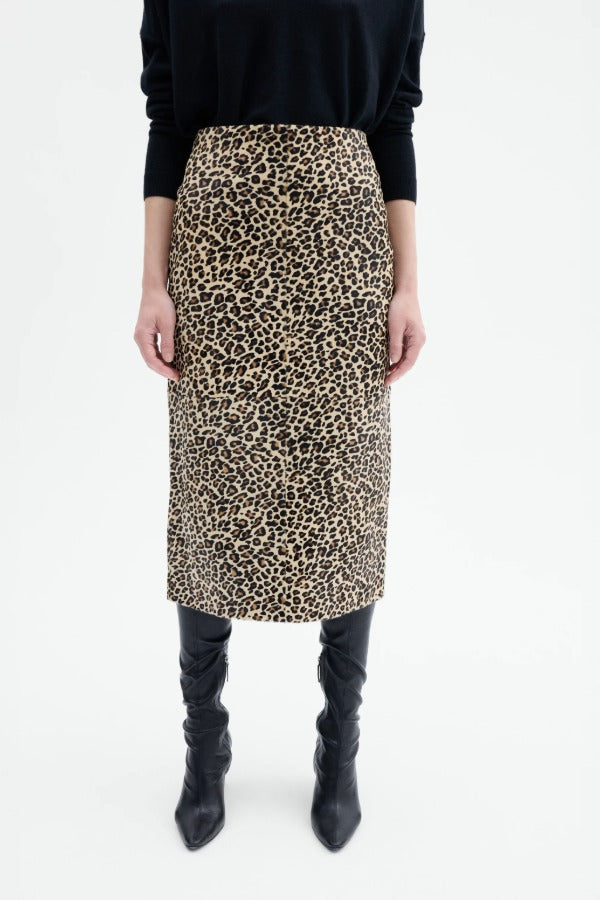 Front closeup view of leopard skirt on model wearing black top and boots, against a white background.