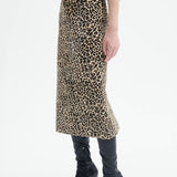Alternate side view of leopard skirt on model wearing black top and boots, against a white background.