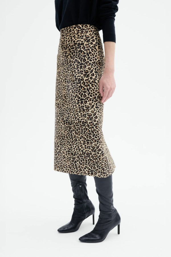 Alternate side view of leopard skirt on model wearing black top and boots, against a white background.