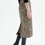Alternate side view of leopard skirt on model wearing black top and boots, against a white background.