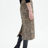 Alternate side view of leopard skirt on model wearing black top and boots, against a white background.