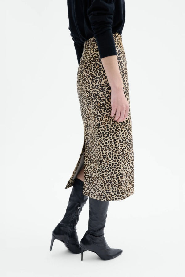 Alternate side view of leopard skirt on model wearing black top and boots, against a white background.