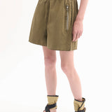 Front Side Closeup view of olive combat short on model swearing dark green tank top and leather wrap sandals on white background.