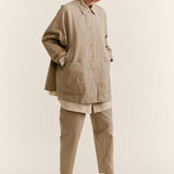 Front slanted view of oatmeal tatiana jacket on model wearing khaki pants and white clogs, against a white background.