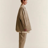 Side view of oatmeal tatiana jacket on model wearing khaki pants and white clogs, against a white background.