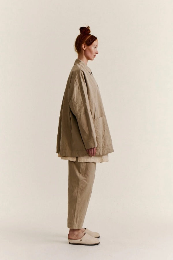 Side view of oatmeal tatiana jacket on model wearing khaki pants and white clogs, against a white background.