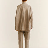 Back view of oatmeal tatiana jacket on model wearing khaki pants and white clogs, against a white background.