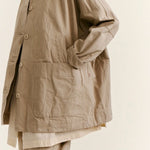 Side closeup view of oatmeal tatiana jacket on model wearing khaki pants, against a white background.