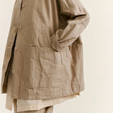 Side closeup view of oatmeal tatiana jacket on model wearing khaki pants, against a white background.