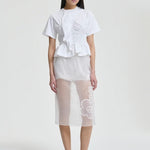 Front view of white ace t-shirt on model wearing white shorts and pink sneakers, against a white background.