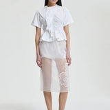 Front view of white ace t-shirt on model wearing white shorts and pink sneakers, against a white background.