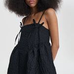 Front closeup view of black ambra dress on model, against a white background.