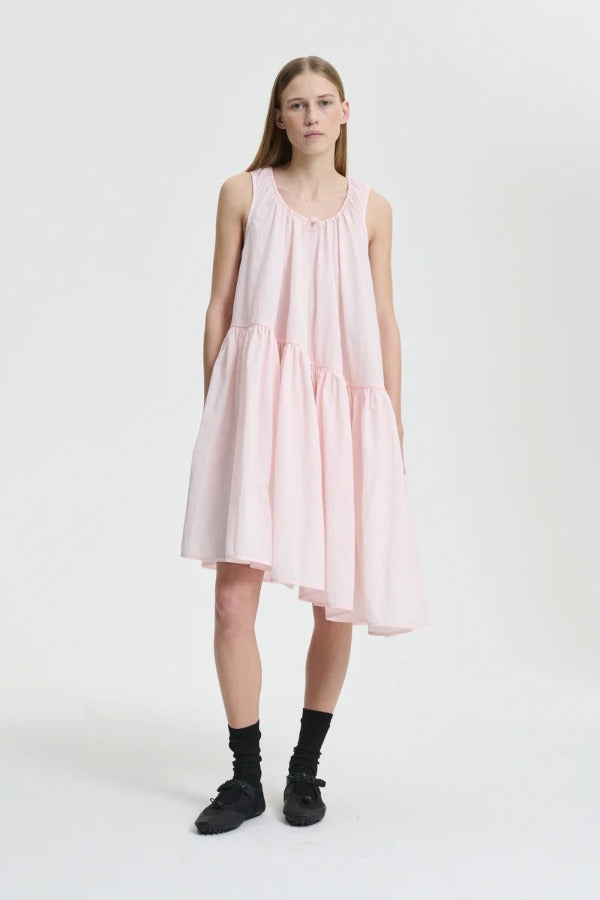 Front view of blush pink azelia dress on model wearing black sneakers and socks, against a white background.