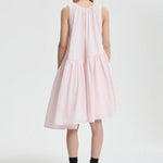 Back view of blush pink azelia dress on model wearing black sneakers and socks, against a white background.
