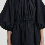 Front closeup of black birgitte dress on model, against a white background.